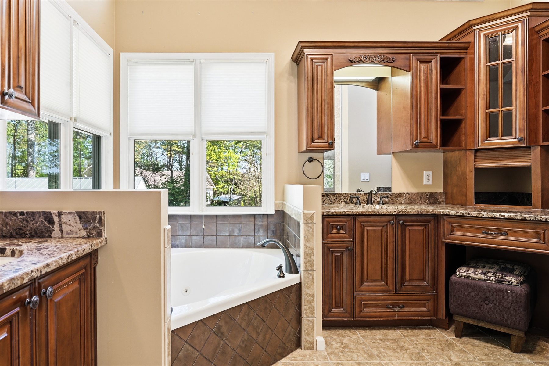 Primary bathroom with soaking tub, large vanity, and custom cabinetry